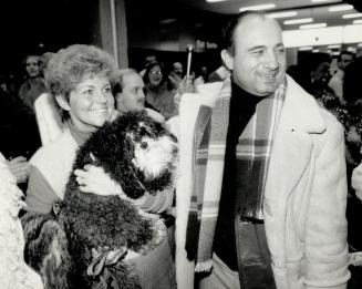 Coach Bob O'Billovich puts arm around wife Judy, with pet dog Tasha, last night at Pearson airport as his Argos returned home from knocking off the Bl(...)