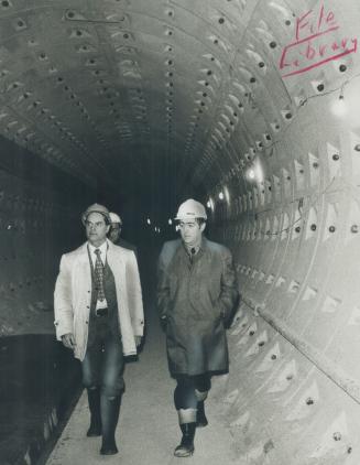 Going underground, Ontario Labor Minister Gordon Carton (left) and Toronto Alderman Tony O'Donohue walk through part of the Yonge St. subway extension(...)