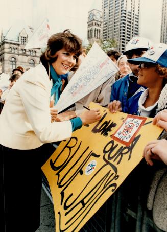Making amends, New York singer Mary O'Dowd autographs signs for fans arriving early for yesterday's Jay Day celebrations at Nathan Phillips Square. Sh(...)