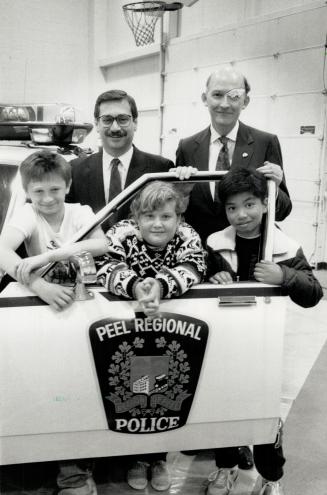 Police week, Solicitor General Steven Offer and Peel Police Chief Robert Lunney, right, gathered with students Drago Radovic, 10, to launch Police Week