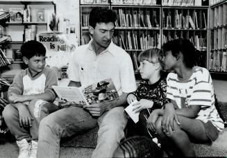 Celebrity reader, Blue Jay designated hitter John Olerud reads Heather Hits Her First Home Run to an admiring trio, from left, Jason Peterkin, 9, Wyat(...)