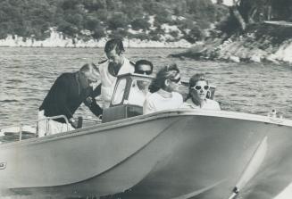 At far left Kennedy sisters Mrs. Stephen Smith and Mrs. Pat Lawford ride on launch with Onassis