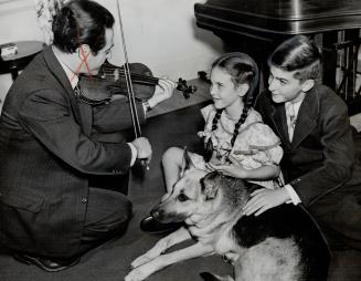 Concert master of the Toronto Symphony which seeks public aid for its sustaining fund, Elie Spiyak plays for Patsy Parr, centre, and his son, David, w(...)