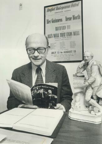 The man behind Stratford, Tom Patterson (1960 photo) in an office with poster from the first festival