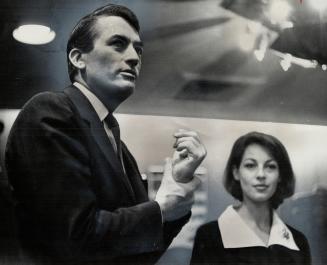 Under glare of camera lights, Mr. and Mrs. Gregory Peck are shown at yesterday's press conference in Royal York. Mrs. Peck was a reporter in Paris