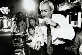Sip and run, Ontario Premier David Peterson drinks from a cup of espresso at an Italian cafe in Toronto yesterday during a stop in his election campaign