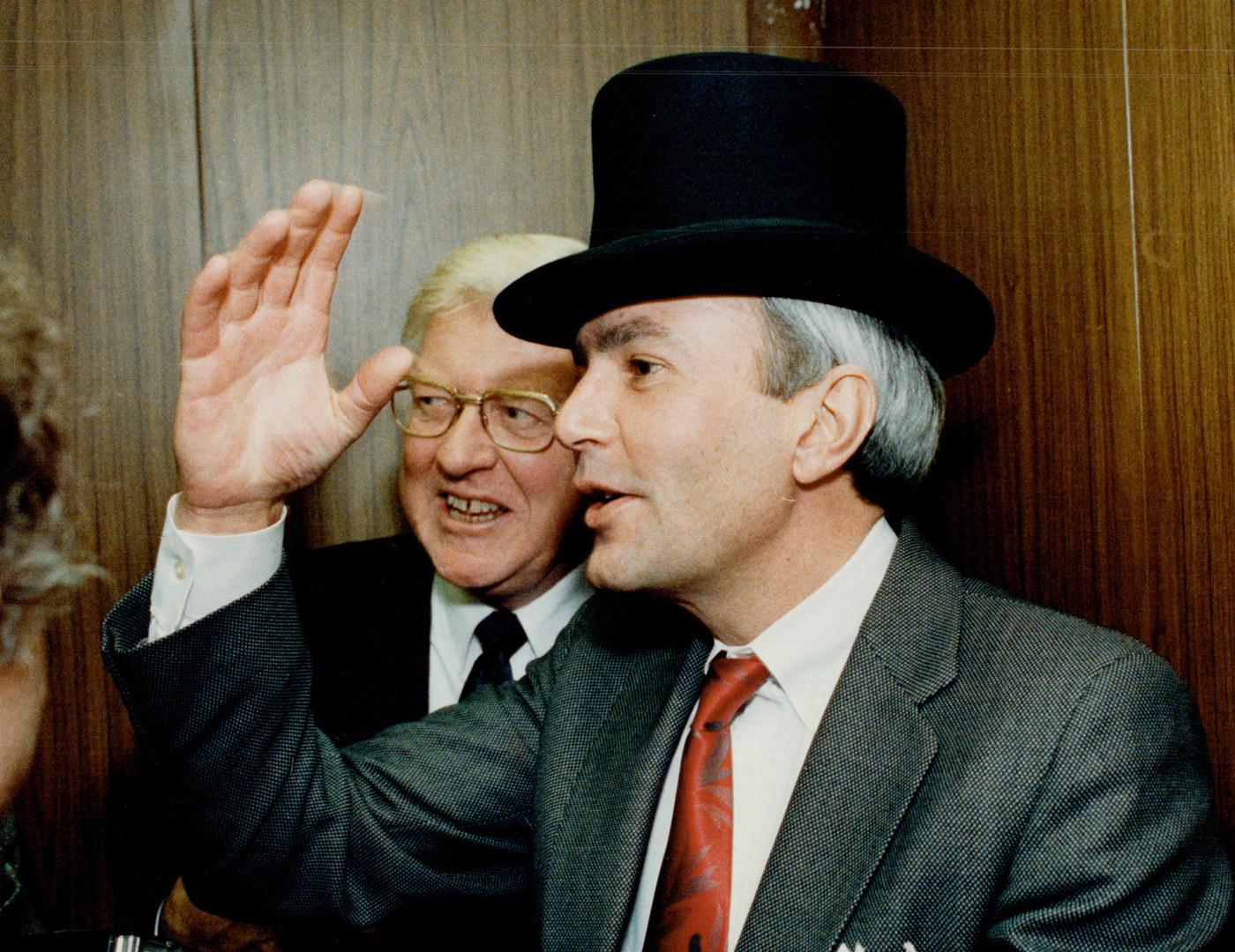 Premier wears a different hat. Premier David Peterson and deputy minister of agriculture Dr. Clayton Switzer celebrate the ministry's 100th anniversar(...)