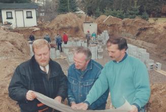 Joey's house, Designer Ivan Cobbe (left) discusses plans with contractor Bill Walters (right) and electrican Ken McCann (middle) while others work on (...)