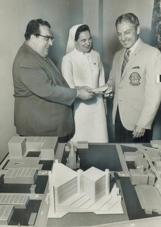 Sixty pounds lighter, Alderman Joseph Piccininni (left) approves the presentation of a cheque for $600 by Fred DeMarco, president of the Colombo Lions(...)