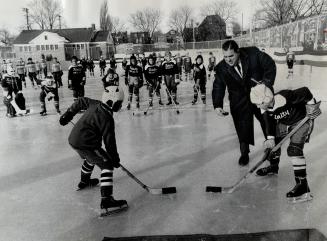 Artificial Ice - who needs it? Alderman Joseph Piccininni prepares to throw in the puck between Bobby Balkeman, 9, of Knob Hill (left) and John Pakert(...)
