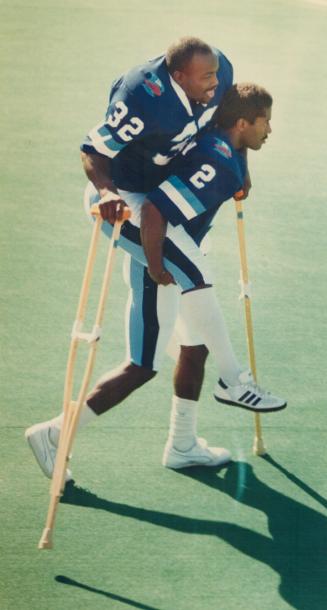 Carrying a big load. Defensive back Carl Brazley of the Argonauts doesn't show much strain as he carries injured linebacker Willie Pless to the team p(...)