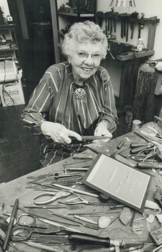 At her workbench Nancy Pocock can forget awhile the horrors she's seen, while making jewelry