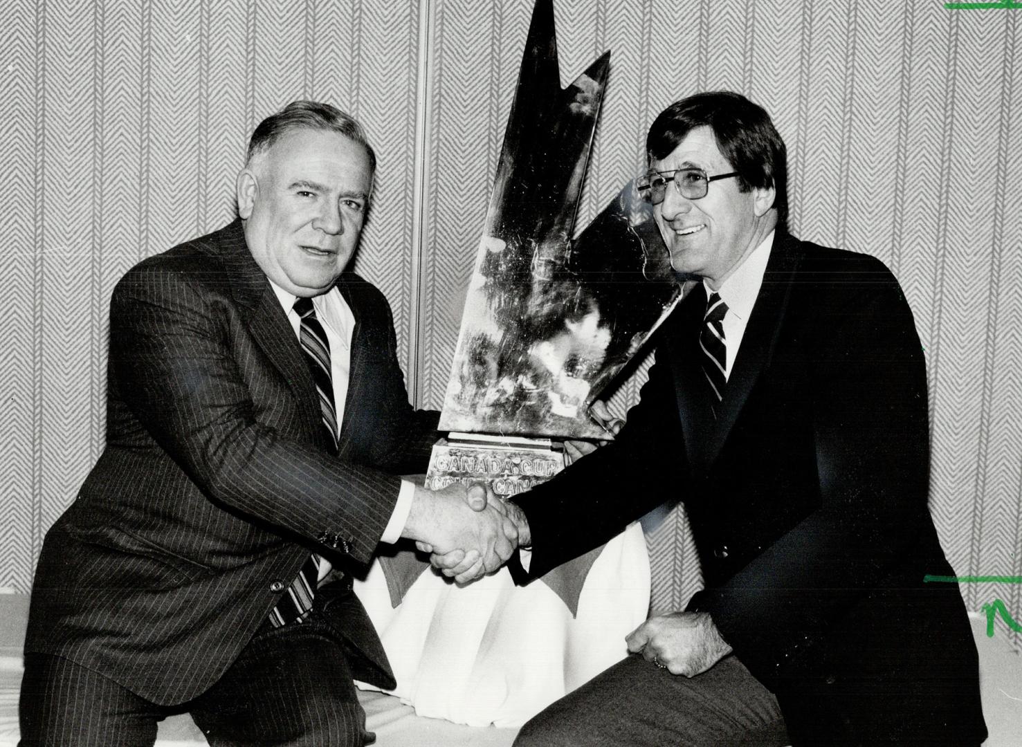 Happy fellows, Sam Pollock, left, chairman of the Canadian Olympic hockey team committee, and Al Eagleson, chairman of the Canada Cup hockey tourney, (...)