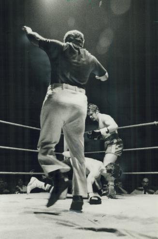 It's all over, Referee Sammy Luftspring steps in to end fight last night as Toronto's Don Poole stands over Bobby Bascombe of Brantford after only 47 seconds of the first round