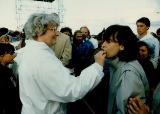 Papal occasion, Pope John Paul II has a moment of solitary prayer and a woman, right, distributes communion at the mass held in Downsview during the r(...)