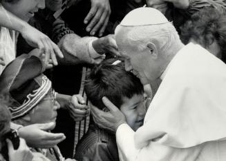 A kiss from a Pope, A young Indian boy is embraced by Pope John Paul II during the pontiff's visit to the world-famous shrine of Ste. Anne de Beaupre (...)