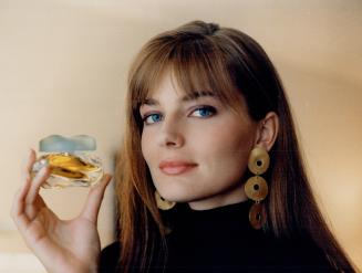 Mega-model Paulina Porizkova gets playful with a bottle of knowing perfume