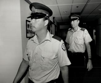 On way out, Constables Rodney Pugh, left, and Gordon Trumbley leave room at police headquarters yesterday after being ordered to resign by a senior police officer