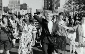Working couple, New Democratic Party leader Bob Rae, and his wife, Arlene Perly Rae, left, wave at the crowds - and do some campaigning - yesterday during Labor Day parade on University Ave