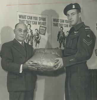 Cpl. Frederick George Topham, V.C., gives his bundle of clothing to the National Clothing Collection chairman, Elwood A. Hughes. Every country in Euro(...)