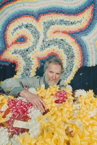 Town's all tied up. Toronto artist Harold Town, 62, is swamped with some of the 100,000 bows to be used on a backdrop he designed for the National Bal(...)