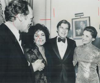Dazzling in a skintight sequinned dress, Margaret Trudeau chats with John Warner, husband of actress Elizabeth Taylor, during reception last night at Canadian Embassy in Washington