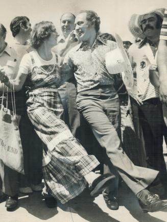 Surrounded by admirers, Prime Minister Pierre Trudeau dances with his wife, Margaret, at the International Picnic on Toronto Island yesterday