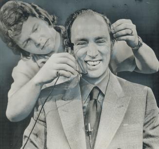 Prime Minister Pierre Trudeau laughs as he is fitted with earphones for a hotline show on a Calgary television station yesterday