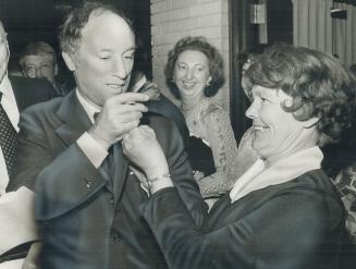 A gallant prime minister Pierre Trudeau takes the rose from his lapel and presents it to delighted waitress Janet Prendergast of Scarborough last night at Beth Tzedec Congregation as he leaves