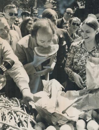 Taking a big bite of watermelon, Prime Minister Pierre Trudeau pauses during an unscheduled 90-minute walk through Kensington Market stalls of fish, fruit and kosher foods today