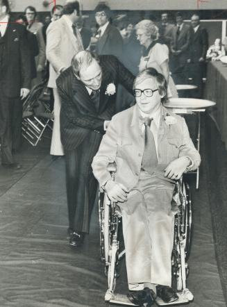 Prime Minister Pierre Trudeau exchanges a word with Harold Parks, president of the Hamilton and District Cerebral Palsy Parents Council, as they enter fund-raising dinner for handicapped