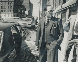 Off to tape a TV show in Toronto today, Prime Minister Pierre Trudeau stands casually outside the Royal York Hotel before entering his limousine on hi(...)