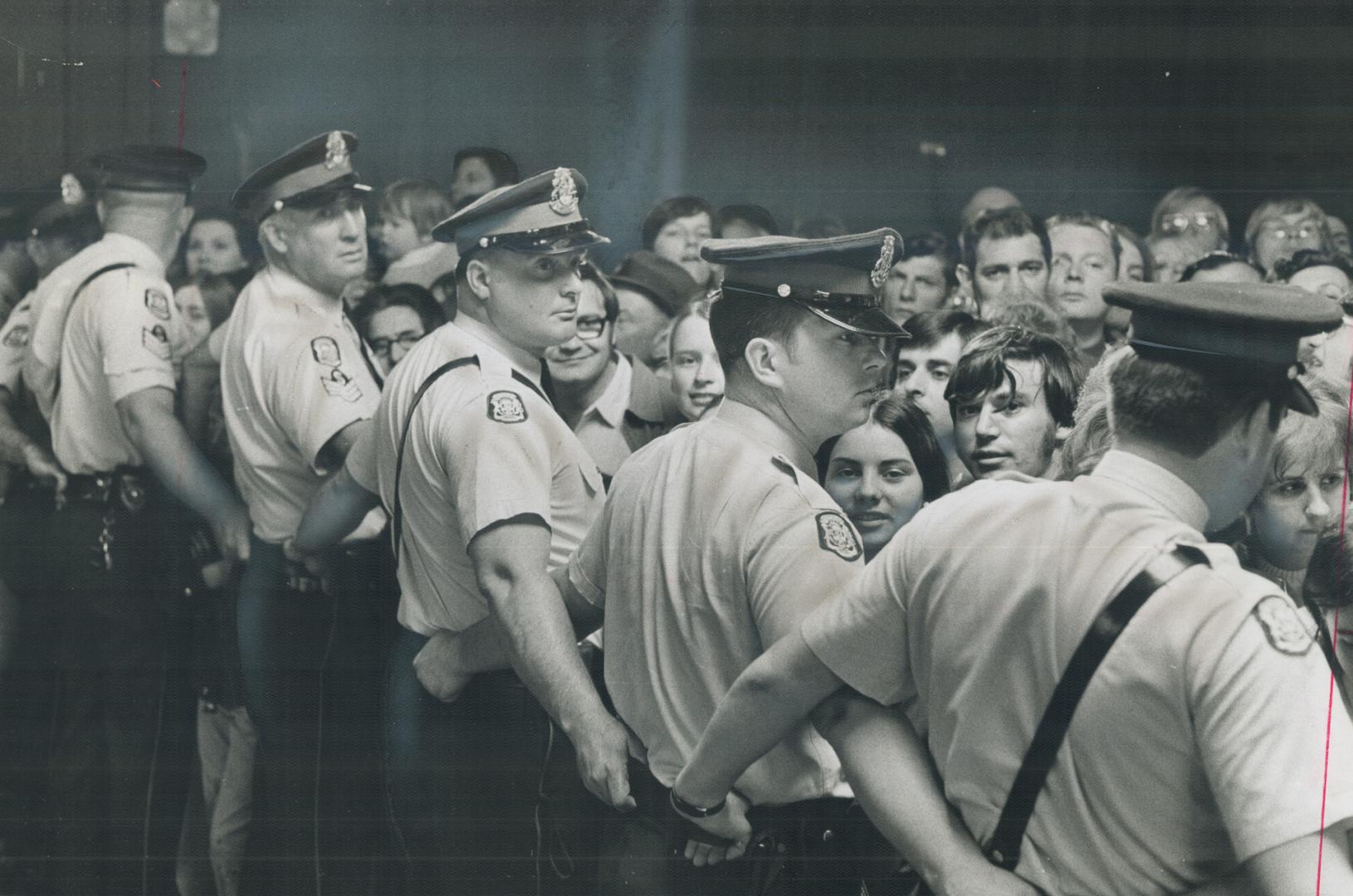 A flying wedge of police, who then linked arms, held back the crowd