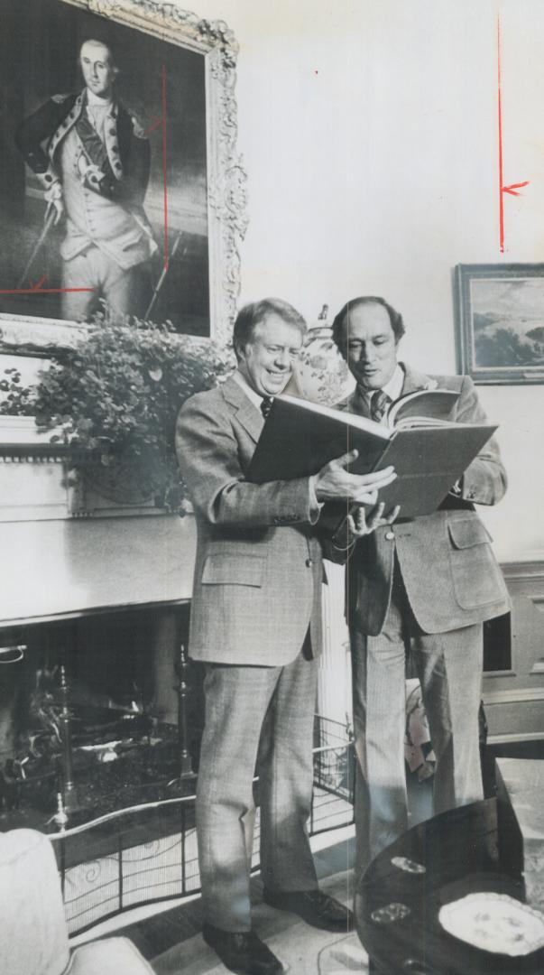 Book presented to him by Prime Minister Pierre Trudeau is inspected by President Jimmy Carter and Trudeau in Oval Room of White House yesterday