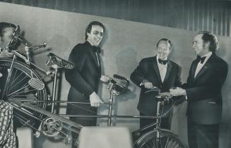A bicycle for two-and-a-hald is presented to Prime Minister Pierre Trudeau for him, his wife, Margaret, and their 2-month-old son, Justin, who gets a (...)