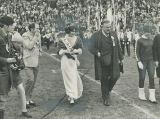 Arriving for kickoff for Grey Cup game Saturday, Prime Minister Pierre Trudeau-somewhat bashful walks across gridiron at Canadian National Exhibition (...)