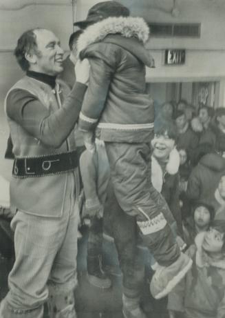 Swinging through the north on his four-day tour of Canada's Arctic, Prime Minister Pierre Trudeau swings a youngster high in the air yesterday during (...)