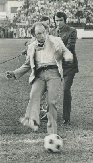 Kicking off to a superstar. Prime Minister Pierre Trudeau kicks off the soccer game at Varsity Stadium last night in which Santos of Brazil defeated Bologna 2-1