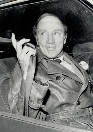 Liberal Leader Pierre Trudeau grabs for his seat belt as he leaves the office to go home