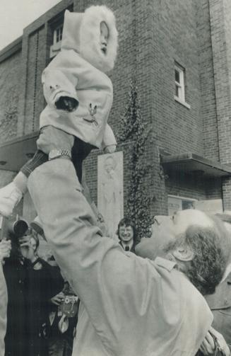 Leaving a polling station in Ottawa today after voting, Prime Minister Pierre Trudeau first swings his son, Justin, 10 months old, high in the air, then bends down to let him-stand on his hands