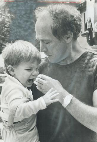 Trudeau calms son after fall. Prime Minister Pierre Trudeau comfort son Michel, 1 1/2, who stumbled and skinned his hand. Michel and brothers, Justin (...)