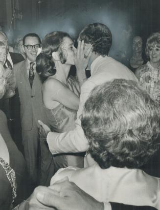 Prime minister gets a reward. Prime Minister Pierre Trudeau gets a loving kiss from his wife, Margaret, 22, in return for picking up a glove she dropp(...)
