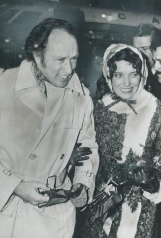 Bringing his bride home: Prime Minister Pierre Trudeau and wife, Margaret, smile despite bitterly cold wind as they walk arm-in-arm on arrival at Ottawa