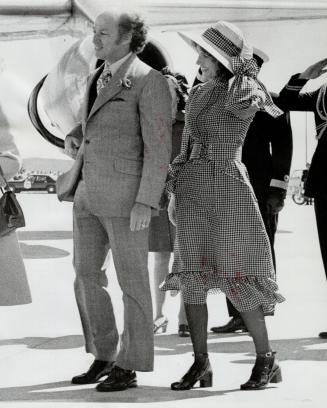 Wearing midi-dress with brown-and-white checks high neck, corsetted waist and a flaring skirt, Mrs