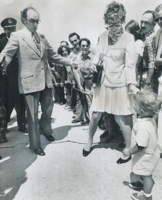 Prime Minister Pierre Trudeau clowns for the amusement of his son, Justin, Saturday after seeing off the Queen and Prince Philip at Ottawa while Mrs. (...)