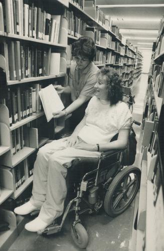 Barbara gets some help selecting a book in the Arizona State University library