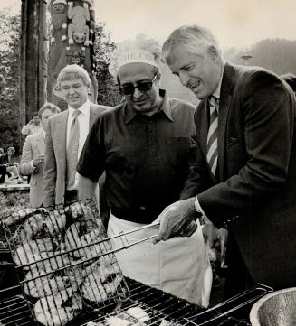 Prime Minister John Turner lends a helping hand in turning over Salmon Steaks during a B-Q