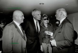 Atlanta Braves owner Ted Turner, left, and wife Jane Fonda listen to former Ontario premier Bill Davis at a reception yesterday in Toronto