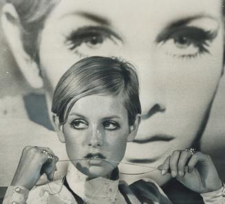 A pensive Twiggy nibbles thoughtfully on her necklace chain as she faces the press today at a conference in the Royal York. She flew into Toronto earl(...)