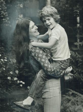 Folksinger and composer Slyvia Tyson romps on the lawn of her Rosedale home with son Clayton, 7